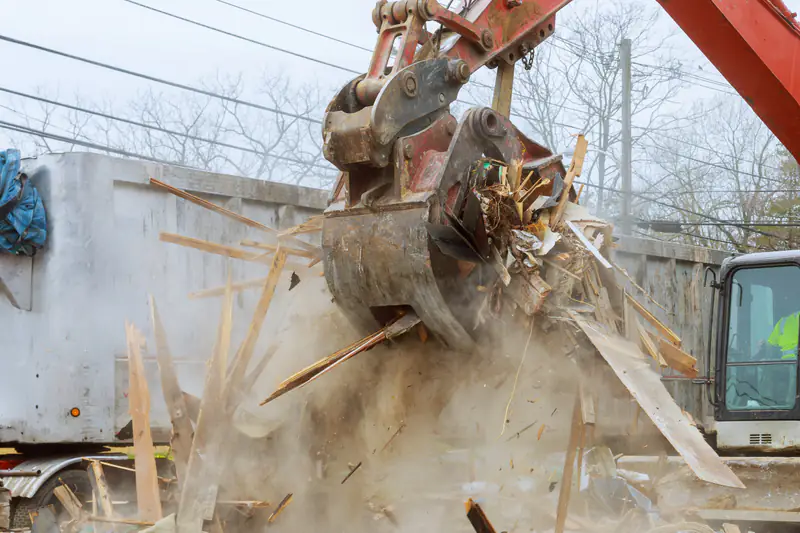 Bagger verlädt Bauschutt auf einen Container-LKW auf einer Baustelle.